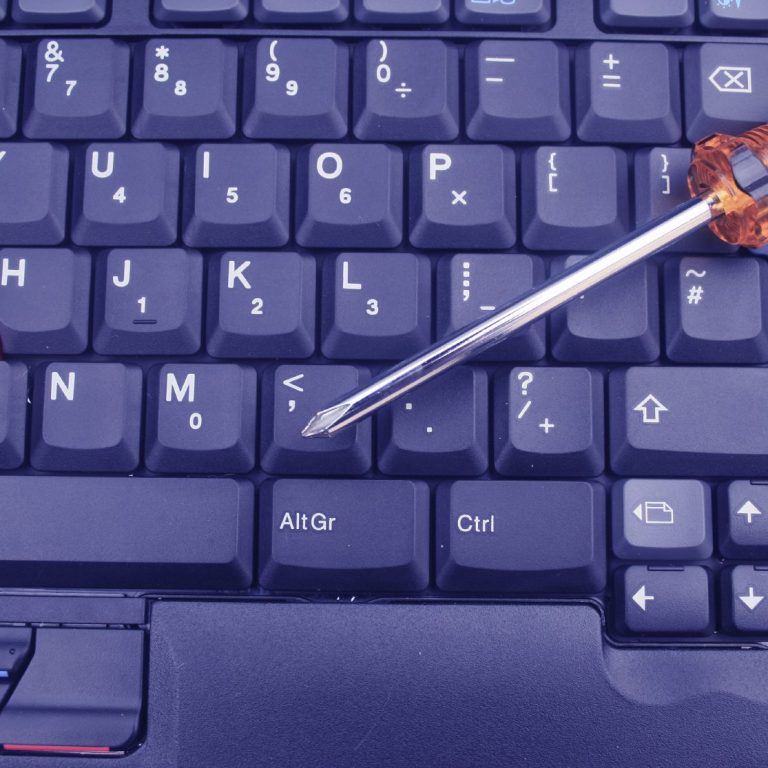 A screwdriver resting on a dark keyboard.